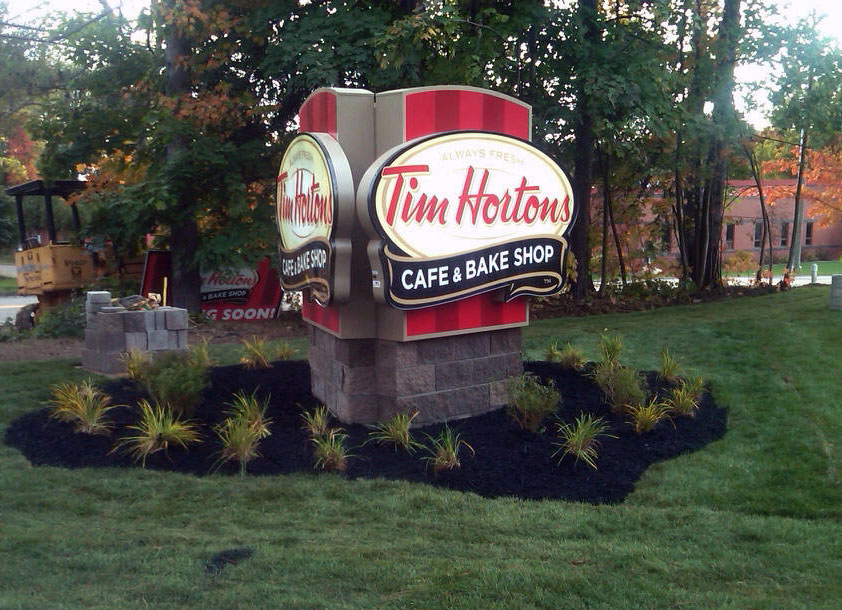 Restaurant signage program including monument and storefront branding.